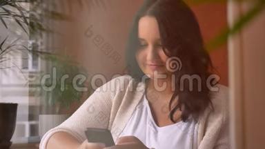 一个大而集中的白种人女孩在咖啡馆里拿着<strong>画报</strong>和打字